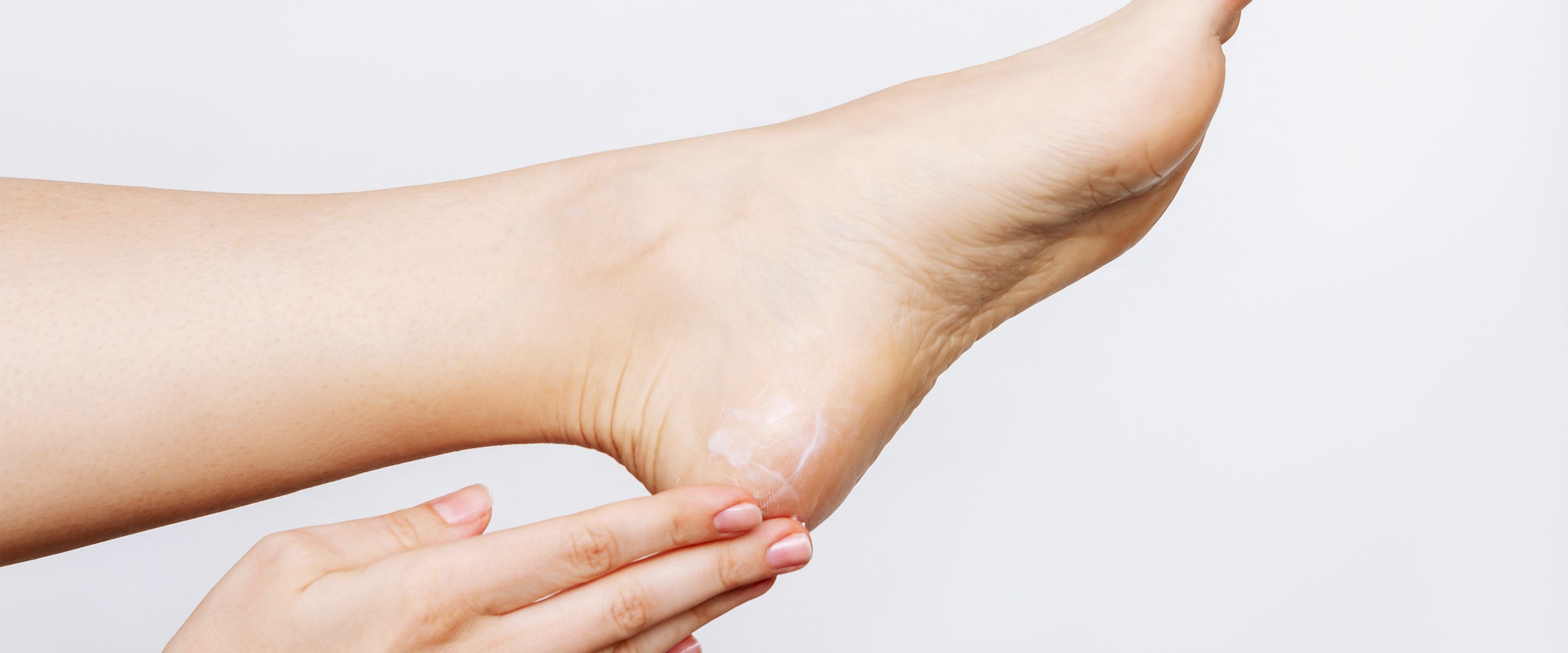 Soins des pieds — application d'une crème hydratante sur un talon sec