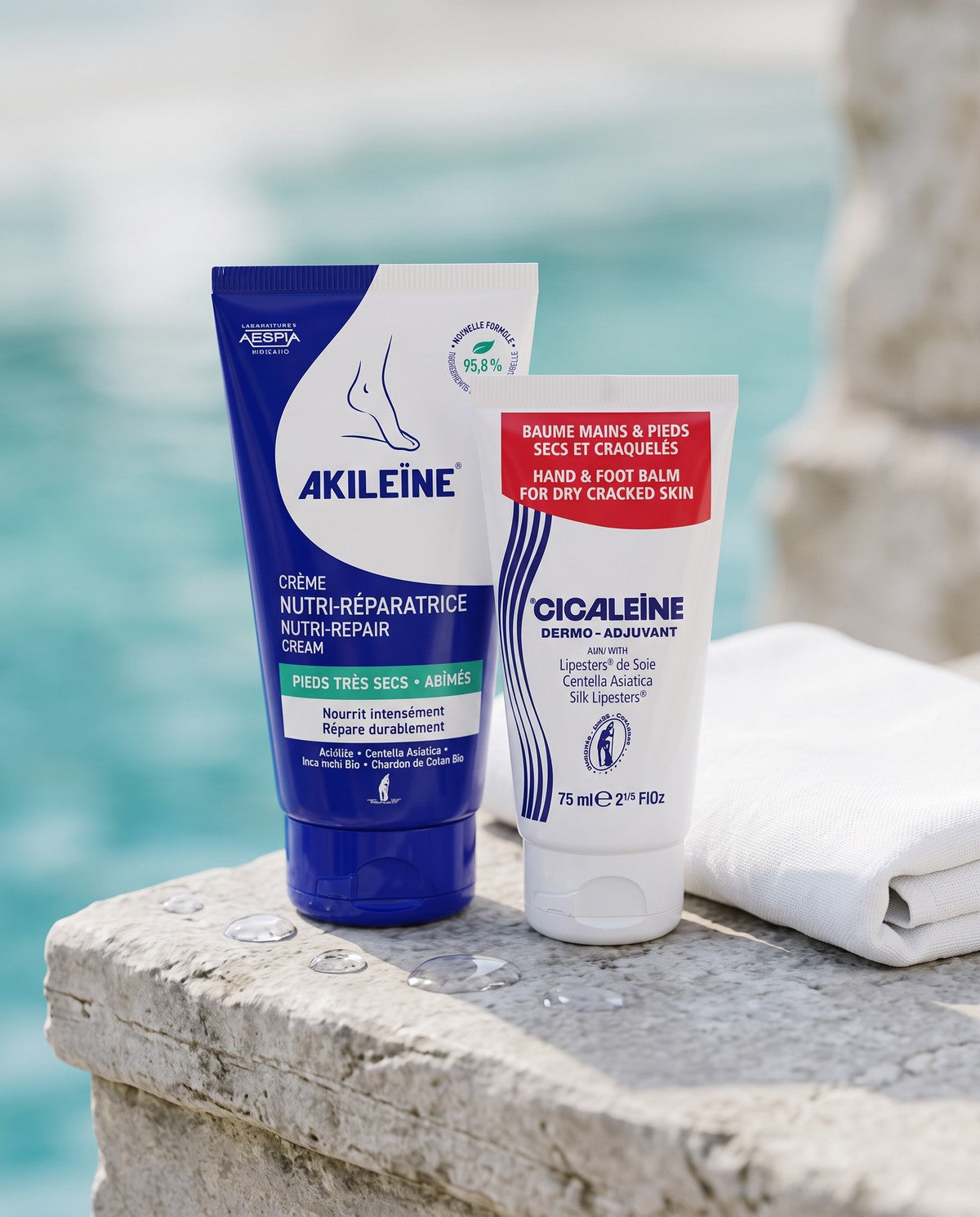 Akileine Nutri-Repair foot cream and Cicaleine balm on a stone step by the sea